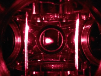 A closeup of the magnetic optical trap (MOT) in Colin Parker's quantum simulator. The glowing spot in the image center is the fluorescence from about 1 billion atoms cooled to less than a 1/1000 of a degree above absolute zero. (Photo Colin Parker)